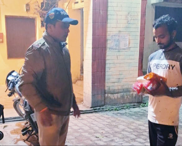 जरूरतमंद शख्स की मदद करते हुए पुलिसकर्मी